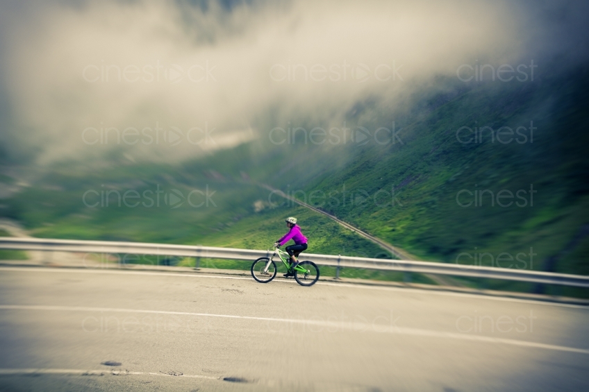 Frau auf Mountainbike aus Distanz vor Nebelwolke 20150817-0276 