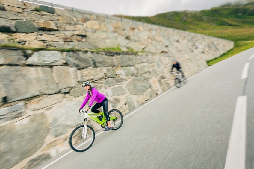 Frau fährt Mountainbike vor Steinmauer 20150817-0172 