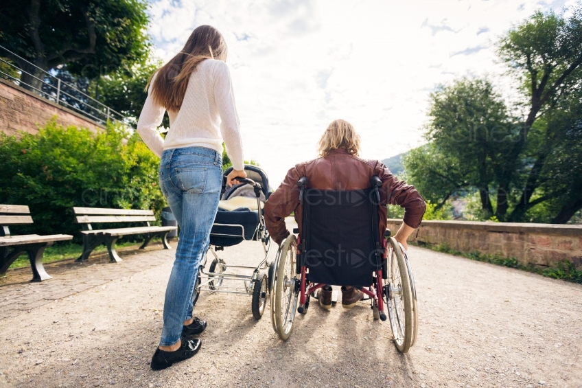 Frau mit Kinderwagen und Mann im Rollstuhl auf Spaziergang 20160810-0207 