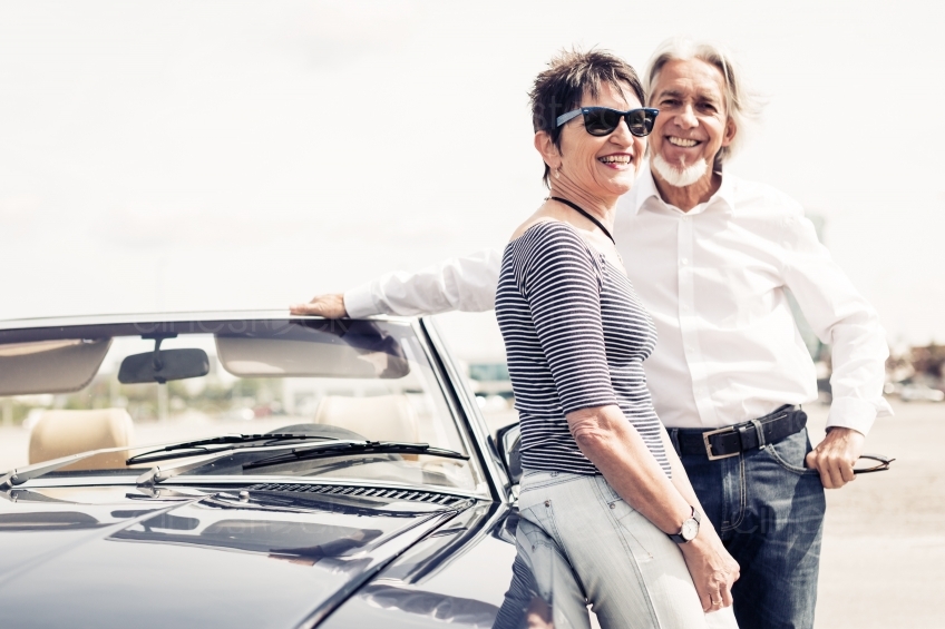 älteres Paar lächelt an Cabrio 20150429-0315