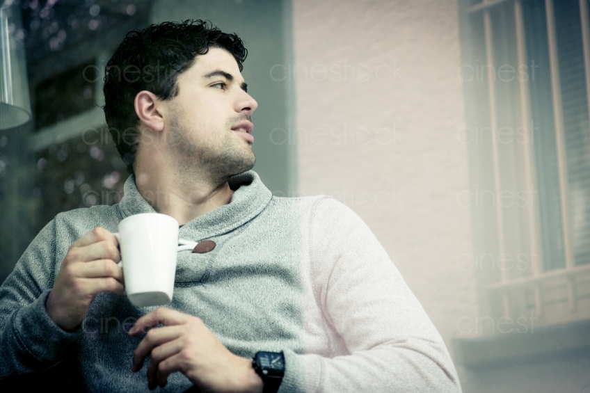 Seitenansicht von Mann mit Kaffee vor Gitterfenster 20150510-0471 