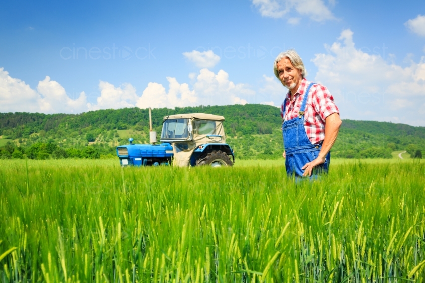 Bauer steht vor Traktor im Feld 20120524_0024 