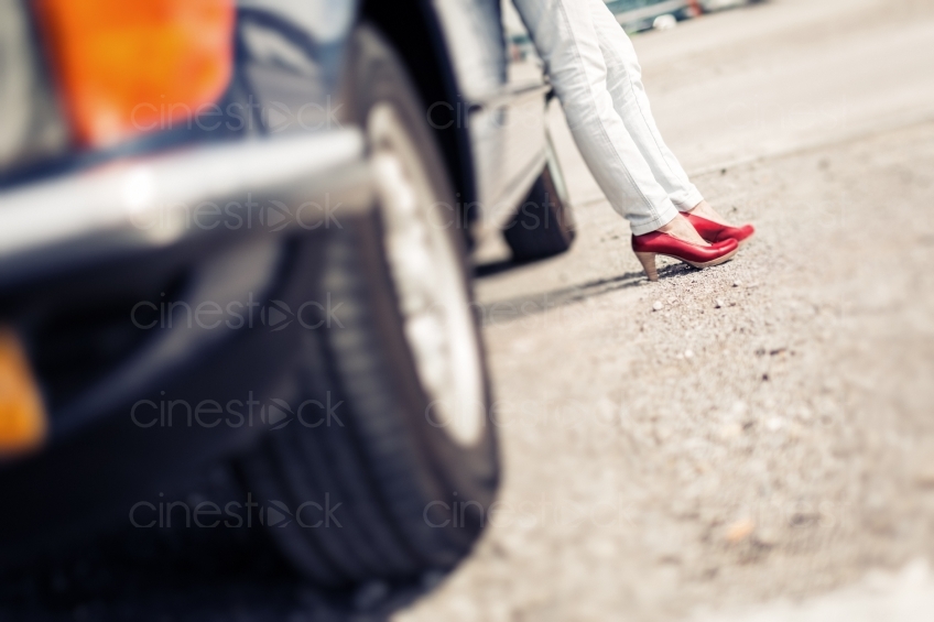 Beine einer Frau mit roten Schuhen an Auto gelehnt 20150429-0404 