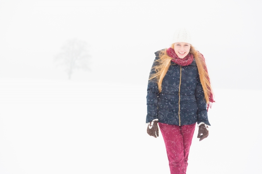 Blonde Frau läuft durch Schneesturm 20130117