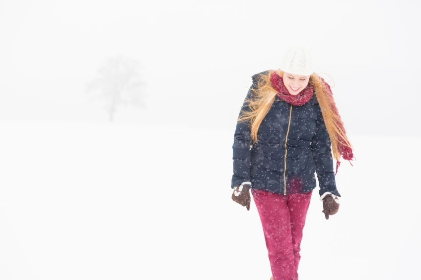 Blonde Frau läuft durch Schneesturm 20130117
