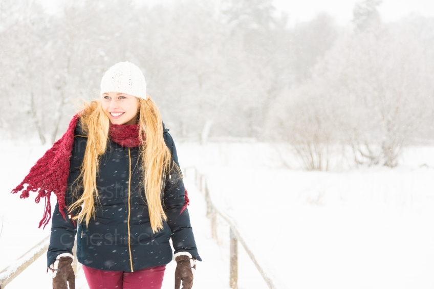 Blonde Frau spaziert im Schnee 20130117