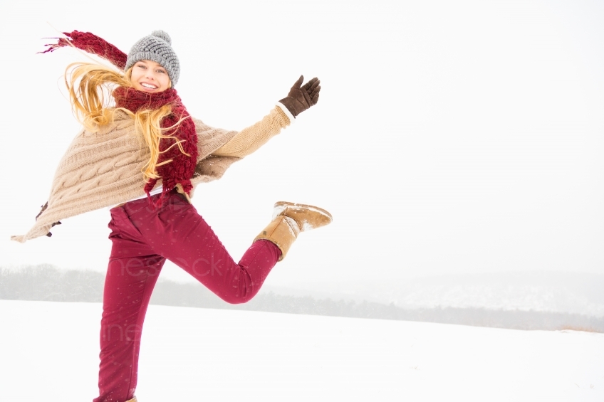 Blonde Frau springt im Schnee 20130117