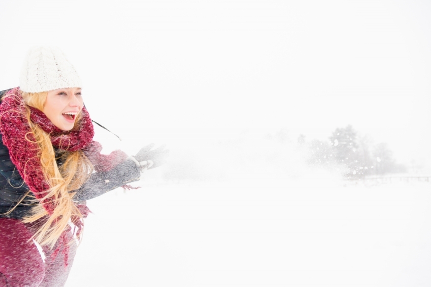Blonde Frau wirft mit Schnee 20130117