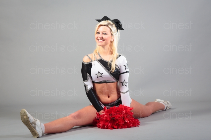 Blonder Cheerleader mit Puschel macht einen Spagat 20120506_0375 