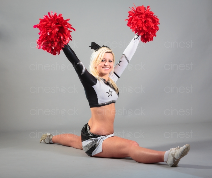 Blonder Cheerleader mit Puschel macht einen Spagat 20120506_0392 