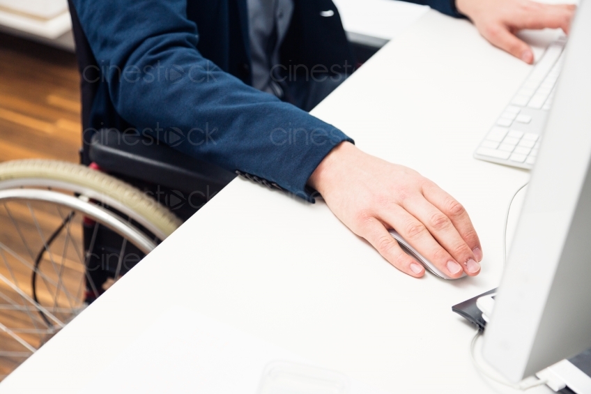 Detailansicht von Rollstuhlfahrer am Schreibtisch 20150510-0121 