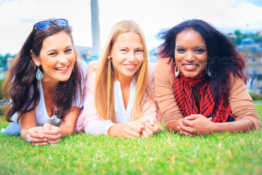Drei Frauen lächeln auf Stadtwiese in Kamera 20120807-901