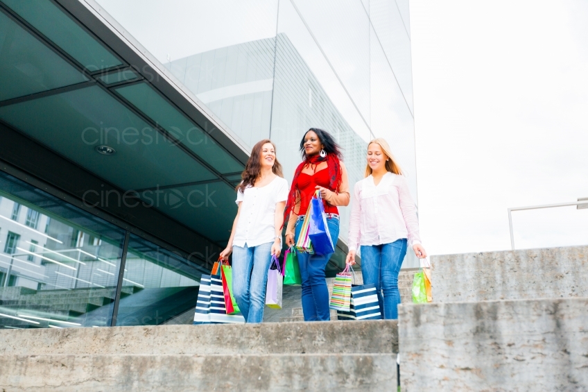Drei Frauen mit ihren Einkaufstaschen laufen graue Treppe hinunter 20120807-576