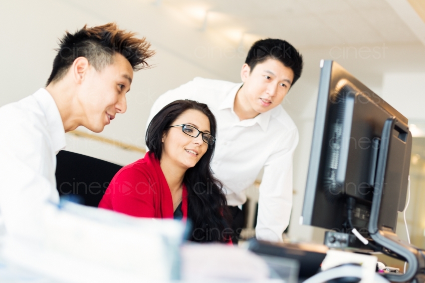 Drei Mitarbeiter am Bildschirm im Büro 20130720-0802