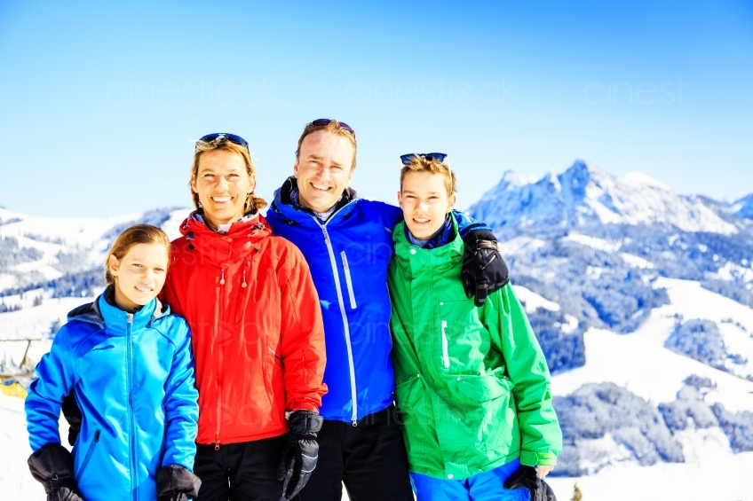 Familie steht auf einem schneebedecktem Berg 20130316