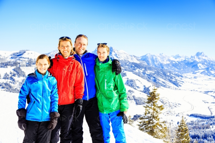 Familie steht auf einem schneebedecktem Berg 20130316