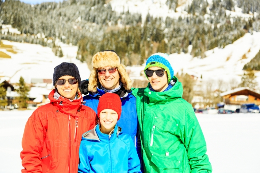 Familie steht vor schneebedeckten Bergen 20130316
