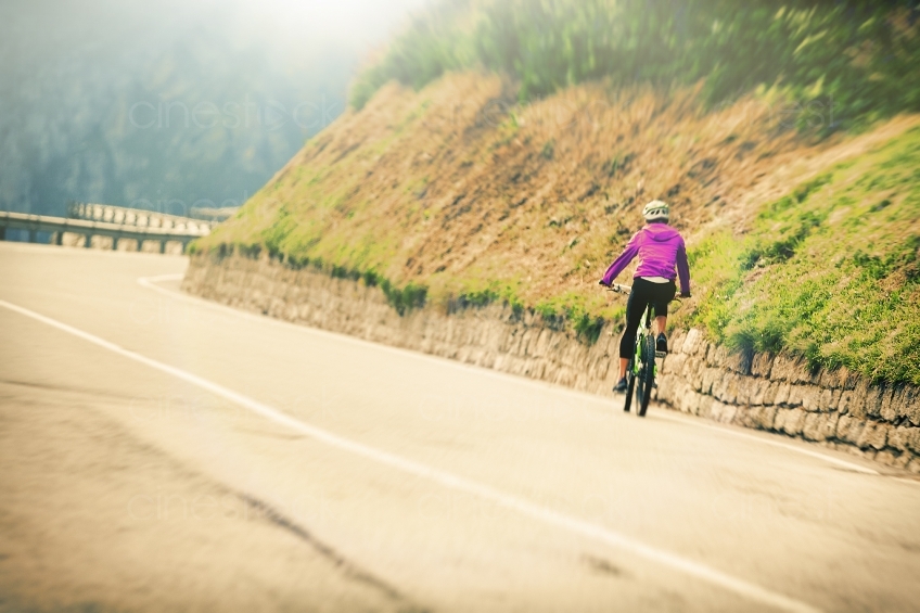 Frau auf Mountainbike vor Kurve 20150817-0285 