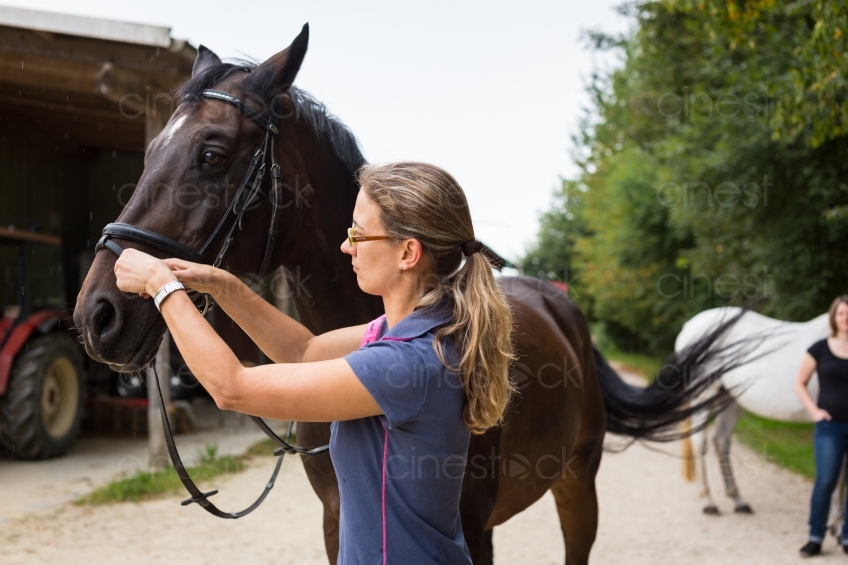 Frau bindet Pferd an 20150913-0900 