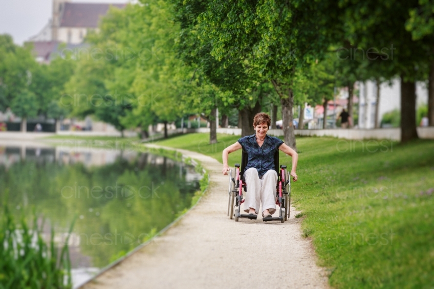 Frau fährt mit Rollstuhl an See 20160725-0654