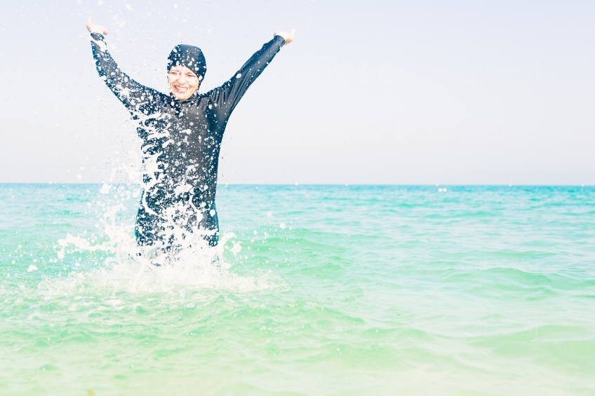 Frau im Burkini springt im Meer 20140313-3538 