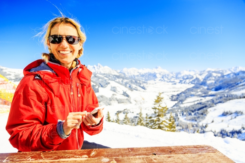 Frau lacht vor schneebedeckten Bergen 20130316