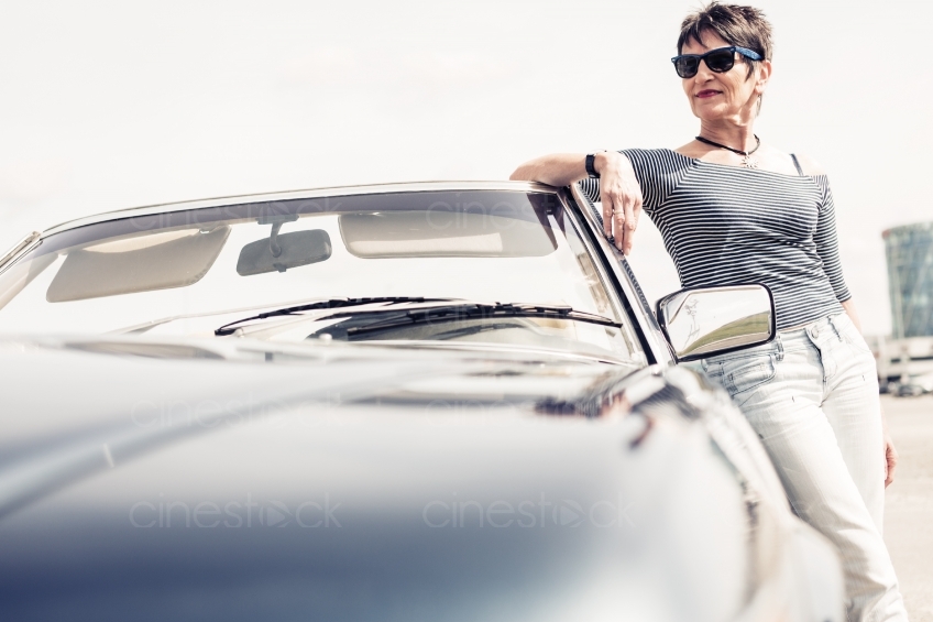 Frau lehnt elegant an Auto 20150429-0333
