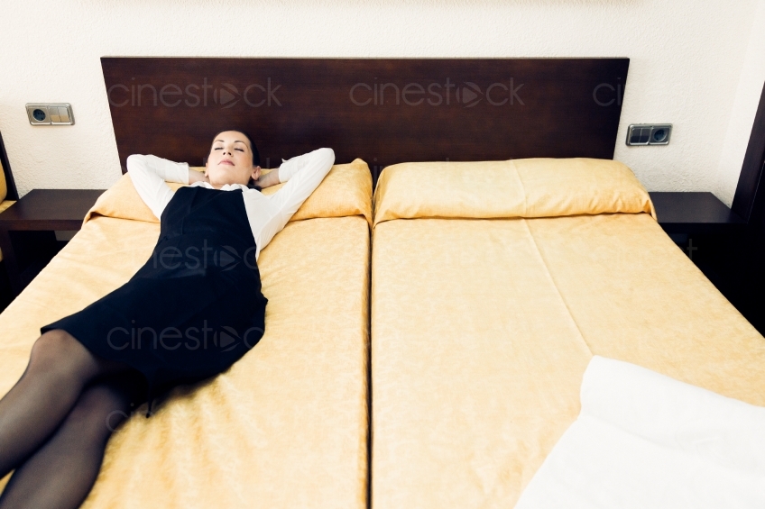 Frau liegt auf Bett in Hotelzimmer 