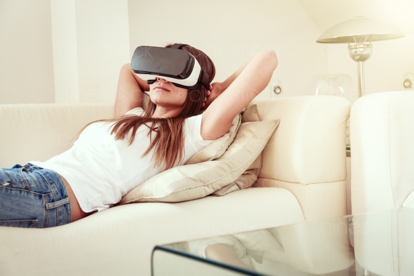 Frau liegt mit VR-Brille auf dem Sofa 20160810