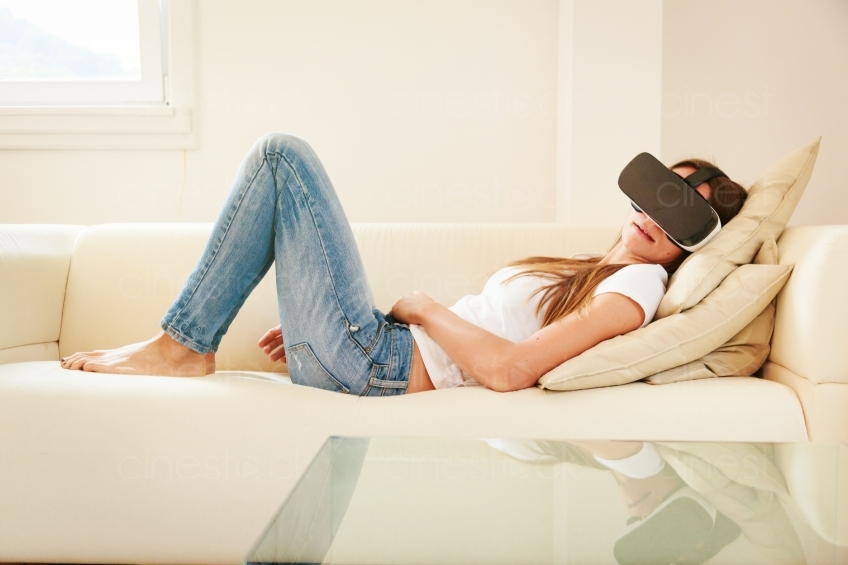 Frau liegt mit VR-Brille auf dem Sofa 20160810
