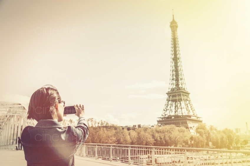 Frau macht ein Foto vom Eiffelturm in Paris 20160426