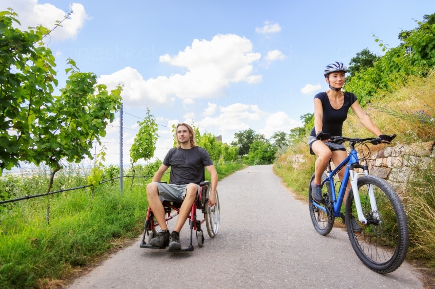 Frau mit Fahrrad  und Mann im Rollstuhl unterwegs 20160718
