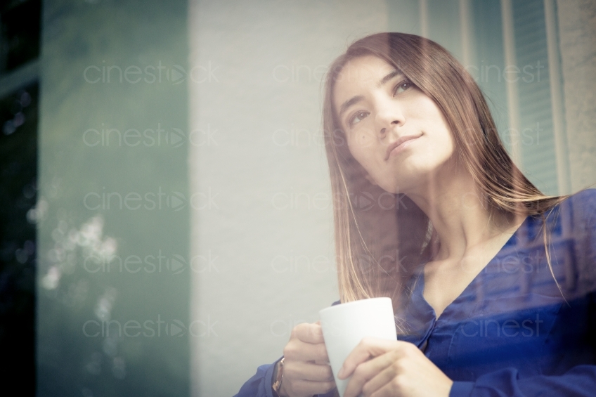 Frau mit Kaffee schaut verträumt 20150510-0454 