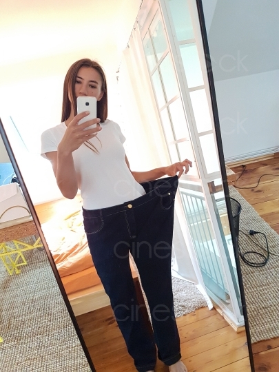 Frau mit zu großer Jeans macht ein Bild vor dem Spiegel 20160810_121229 