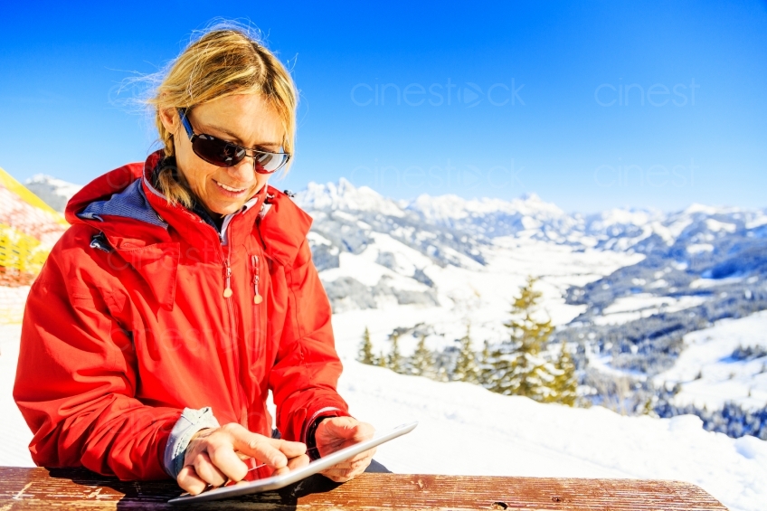 Frau schaut auf Karte vor schneebedeckten Bergen 20130316