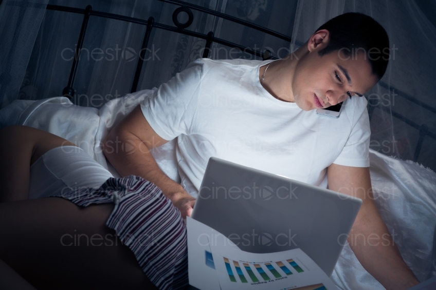 Frau schläft neben arbeitendem Mann im Bett 20121130-450