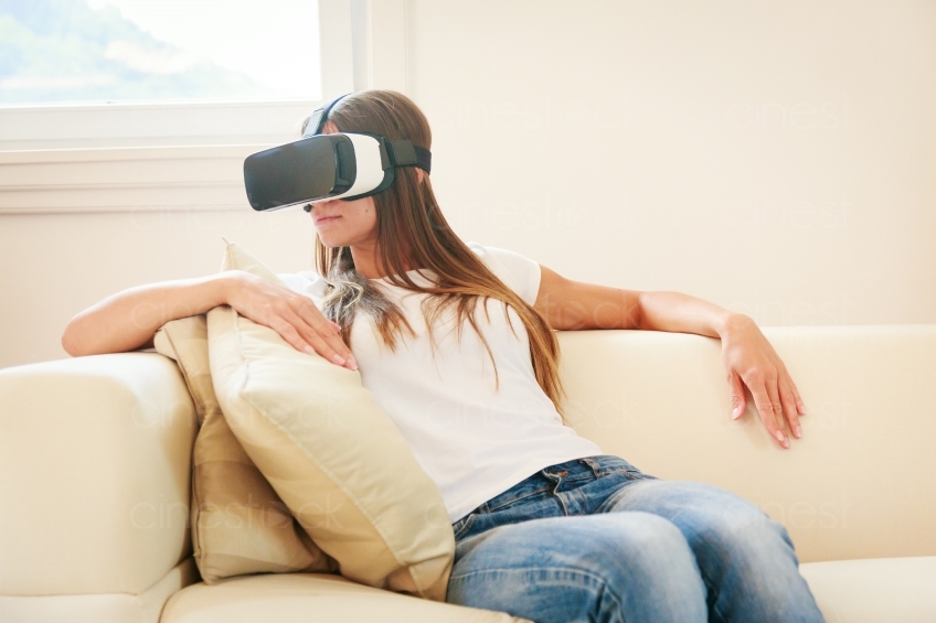 Frau sitzt mit VR-Brille auf dem Sofa 20160810