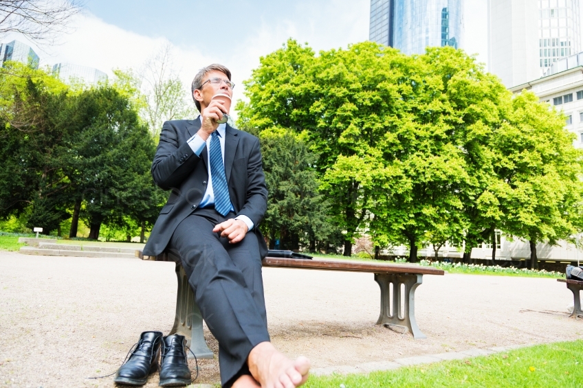 Geschäftsmann auf einer Parkbank beim Entspannen 20130503
