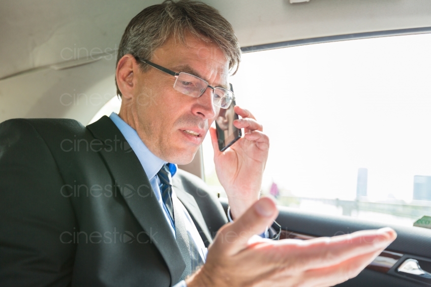 Geschäftsmann telefoniert im Auto 20130503