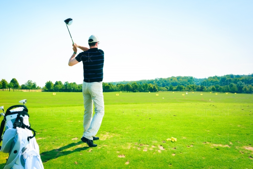 Golfer mit Golfbag und erhobenem Schläger 20120811-50