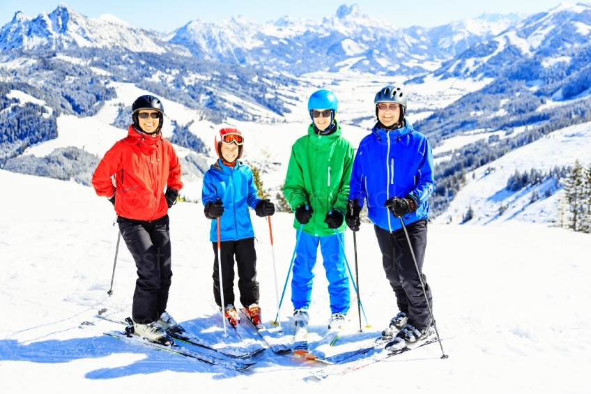 Gruppe von Skifahrern steht vor schneebedeckten Bergen 20130316