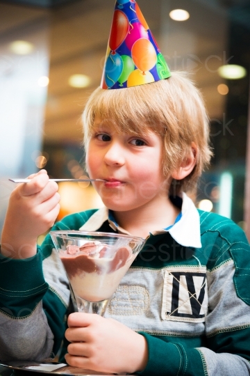 Junge mit Partyhut beim Eis essen 20121115