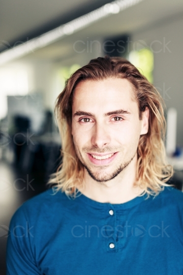 Junger Mann mit langen Haaren im Profil im Büro 20150510-0805