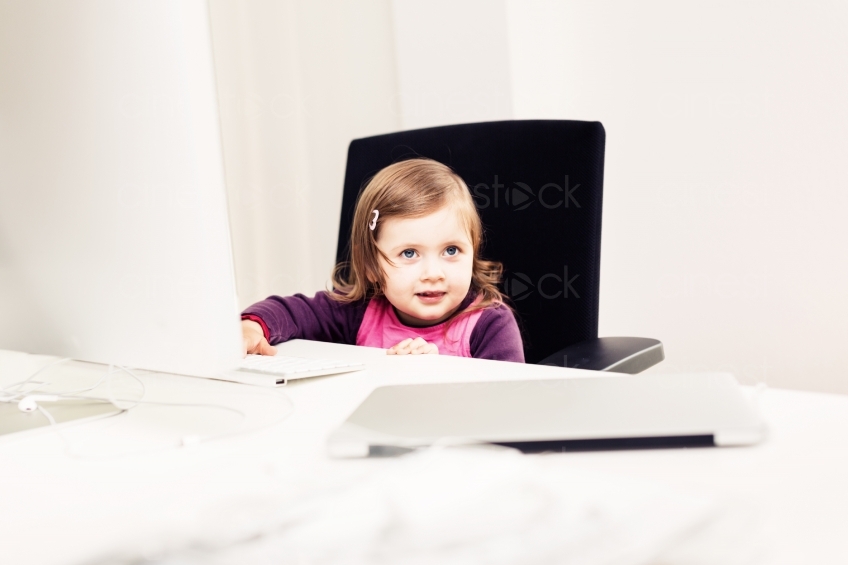 Kleines Mädchen am Schreibtisch im Büro 20150510-0286