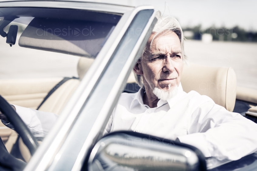 Älterer Mann am Steuer von Cabrio 20150429-0280 