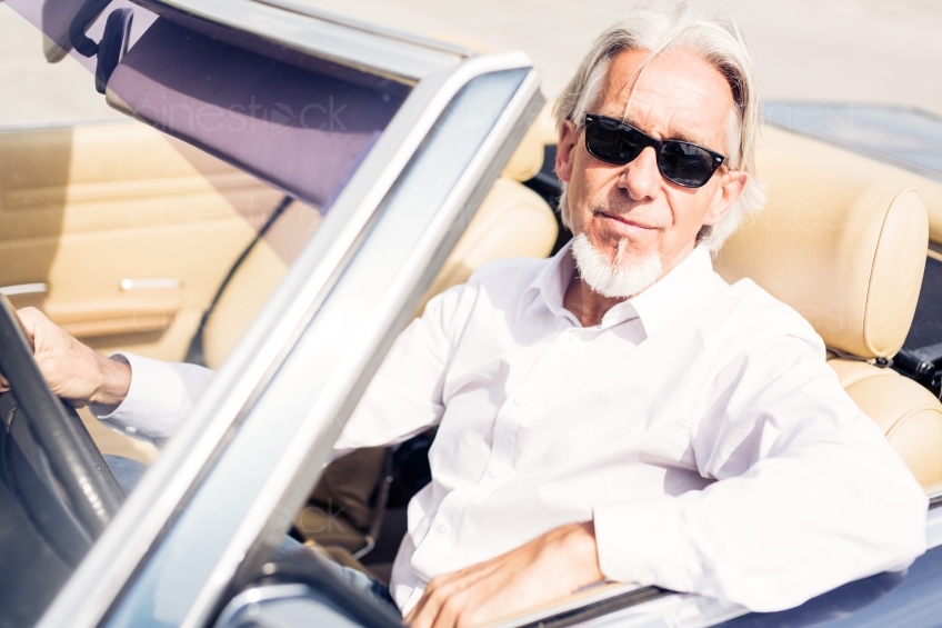 Älterer Mann mit Sonennbrille in Cabrio 20150429-0275 