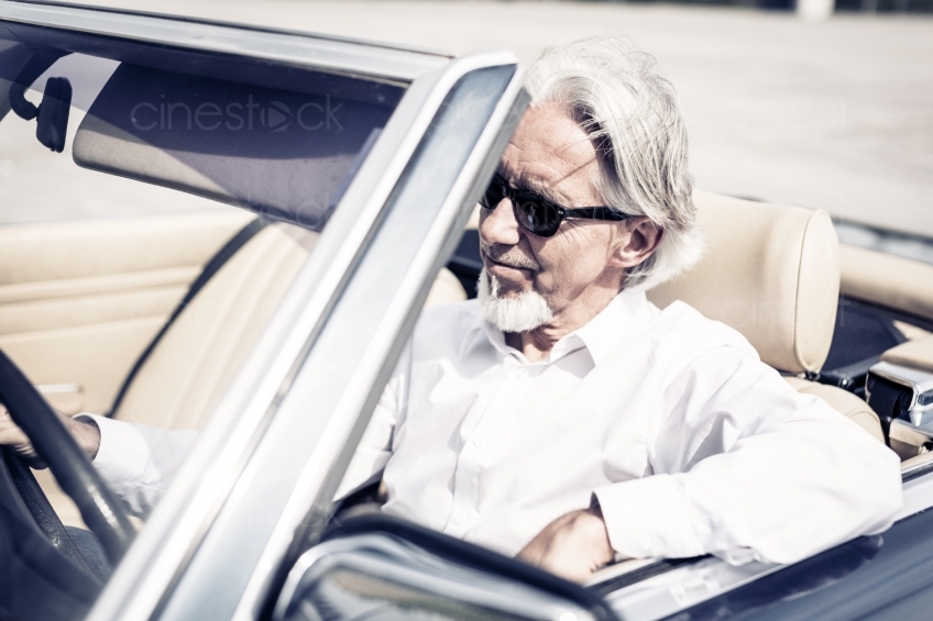Älterer Mann mit Sonnenbrille in Cabrio 20150429-0278 
