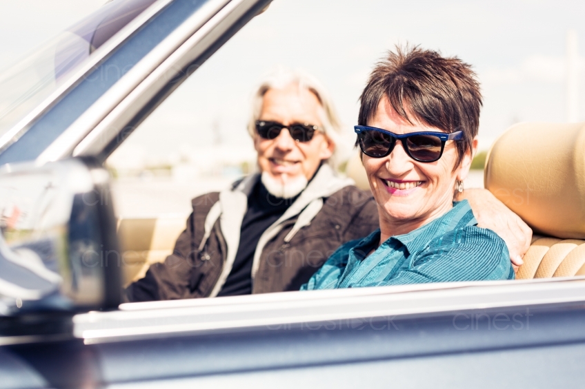 Älteres Paar in Cabrio mit Sonnenbrillen 20150429-0157