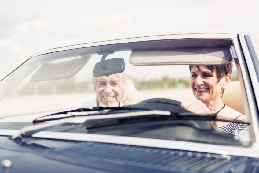 Älteres Paar lacht an Steuer von Cabrio 20150429-0355