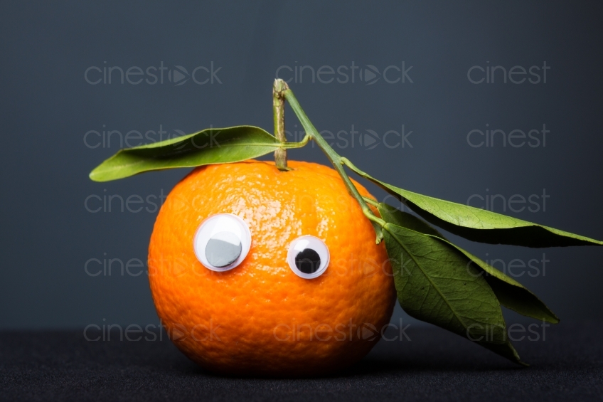 Mandarine mit Augen vor schwarzem Hintergrund 20130110
